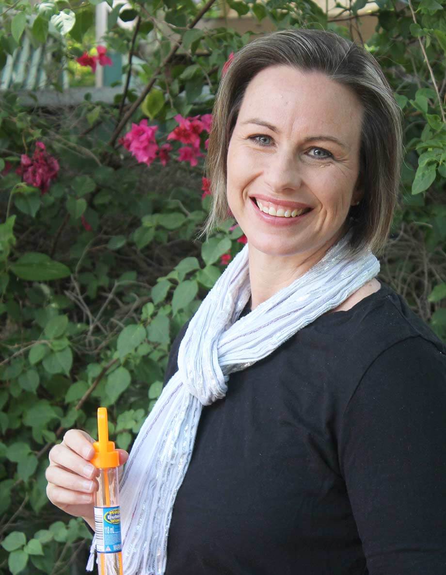 Lauren Scott, online speech pathologist, holding bubbles in a garden.